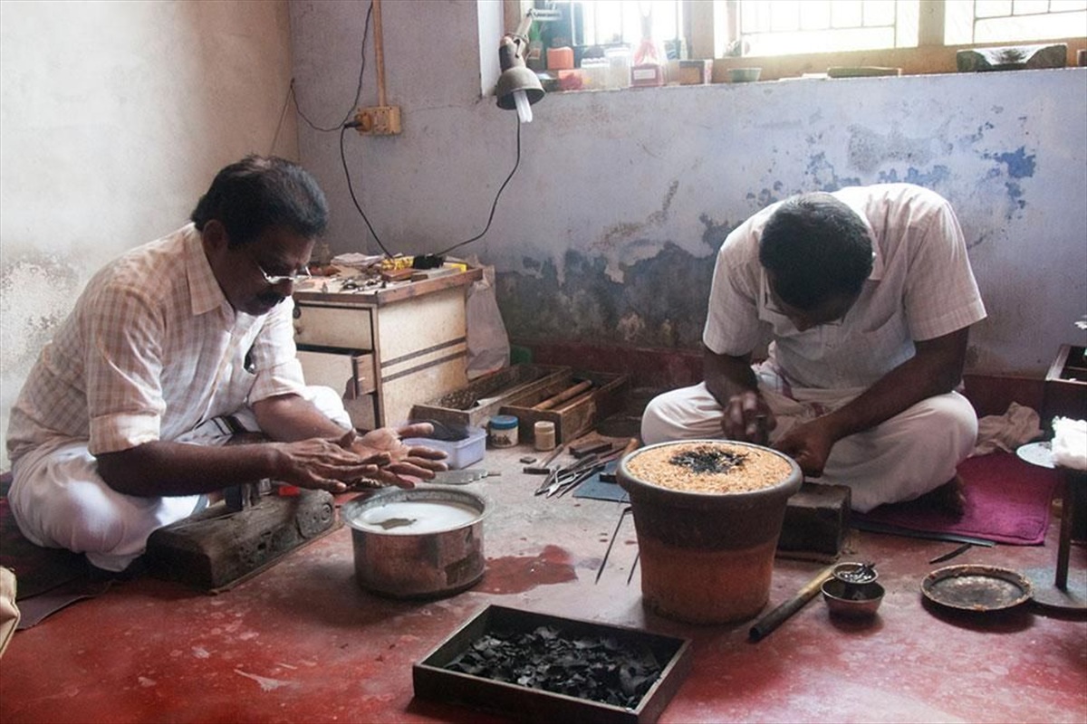 Artisan engraving a gold bangle at a workbench
